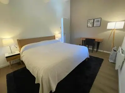 a bedroom with a large white bed and a desk at Villa luxueuse à Ménerbes + piscine in Ménerbes