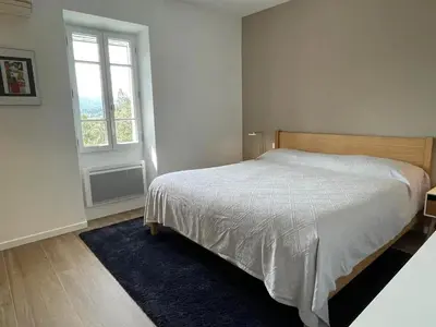 a white bedroom with a bed and a window at Villa luxueuse à Ménerbes + piscine in Ménerbes