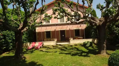 two pink chairs in the yard of a house at Villa élégante à Cavaillon avec piscine in Cavaillon