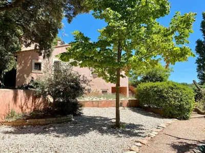 a tree in front of a pink house at Villa Mireyos in Rognes