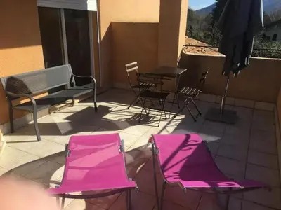 two pink chairs and a table on a patio at Villa spacieuse à Cavaillon avec piscine privée in Cavaillon