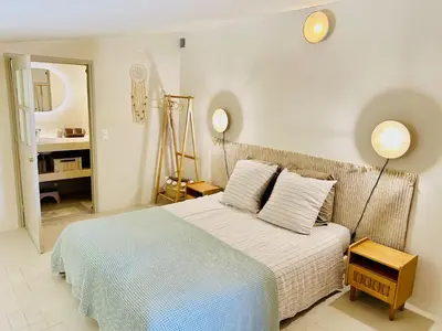 a bedroom with a bed with a blue and white blanket at Maison Joucas in Joucas