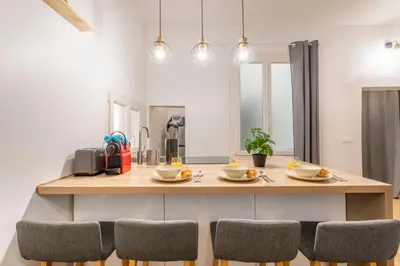 a kitchen with a counter with chairs around it at Studio Aixois Mezzanine in Aix-en-Provence
