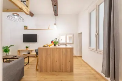 a living room with a couch and a kitchen with a counter at Studio Aixois Mezzanine in Aix-en-Provence