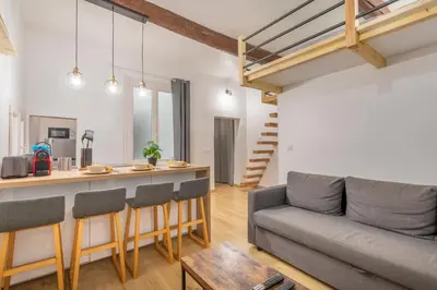 a living room with a couch and a table at Studio Aixois Mezzanine in Aix-en-Provence