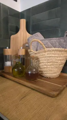 a wooden tray with two bottles and a basket on it at Petit bonheur in Lauris