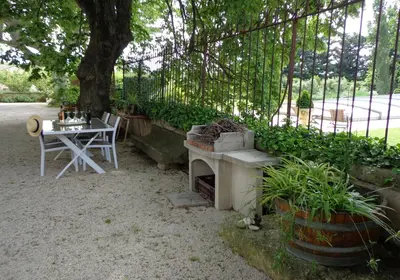 a garden with a table and a table and a tree at Domaine Les Rivales in Cavaillon