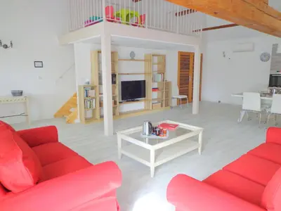 a living room with a red couch and a table at Domaine Les Rivales in Cavaillon