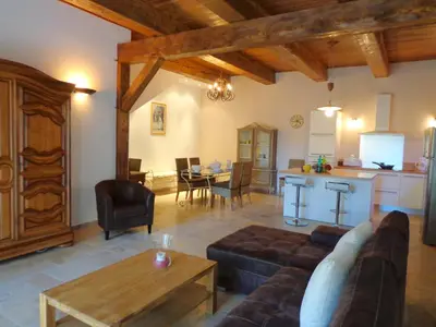 a living room with a couch and a table and a kitchen at Domaine Les Rivales in Cavaillon