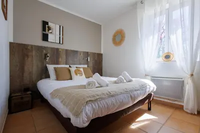 a bedroom with a bed with towels on it at Lou Karo - Piscine partagée - Parking privé in Gordes