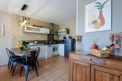 a kitchen with a table and a dining room at Lou Karo - Piscine partagée - Parking privé in Gordes