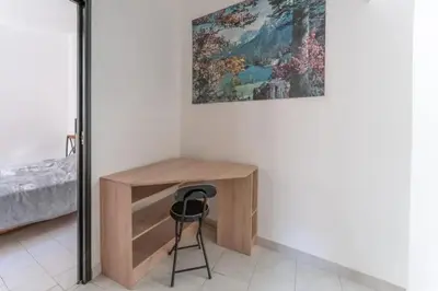 a desk in a bedroom with a painting on the wall at Appartement moderne à L'Isle-sur-la-Sorgue, 50 m² avec parking. in LʼIsle-sur-la-Sorgue