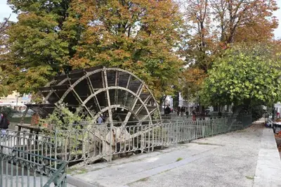 a fence in front of a bunch of trees at Appartement moderne à L'Isle-sur-la-Sorgue, 50 m² avec parking. in LʼIsle-sur-la-Sorgue