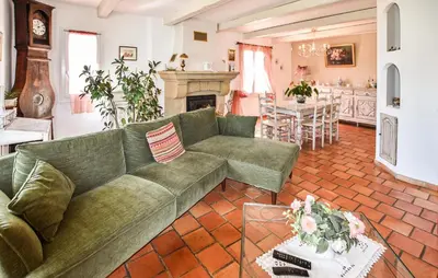 a living room with a green couch and a fireplace at Beautiful Home In La Bastide-Des-Jourdan in La Bastide-des-Jourdans