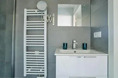 a bathroom with a sink and a mirror at Sérénité au fil de l'eau Appartement de standing in LʼIsle-sur-la-Sorgue