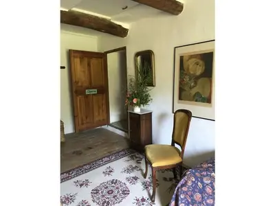 a room with a bed and a chair and a door at Oud Wijnhuis Mas in Sénas