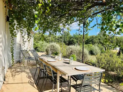 a wooden table and chairs on a patio at La villa Louca in Saint-Saturnin-les-Apt