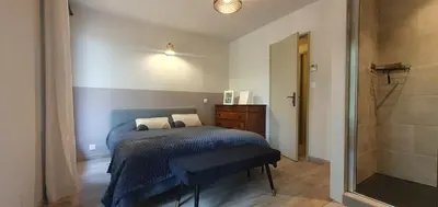 a bedroom with a blue bed and a shower at Odette du Colorado, vue sur le colorado, jacuzzi, boisé in Rustrel