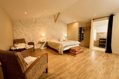 a bedroom with a bed and a chair and a table at Maison avec jardin in Pernes-les-Fontaines