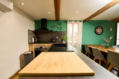 a kitchen with green walls and a wooden table at Maison avec jardin in Pernes-les-Fontaines