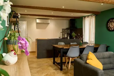 a kitchen and living room with a table and chairs at Maison avec jardin in Pernes-les-Fontaines