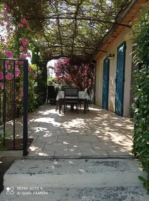 a patio with a table and a fence at Le Cabanon d'Amandine et Gabriel in Blauvac