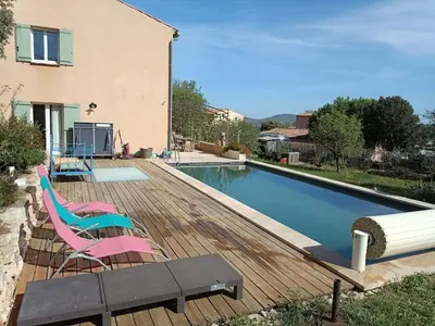 a wooden deck with chairs and a swimming pool at Villa Reillanne Luberon in Reillanne