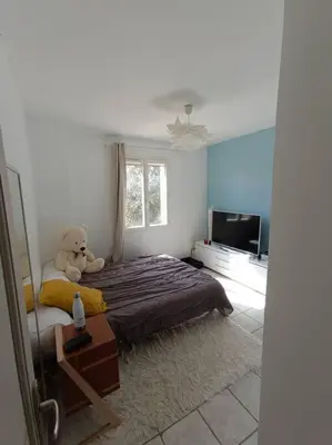 a bedroom with a teddy bear sitting on a bed at Villa Reillanne Luberon in Reillanne