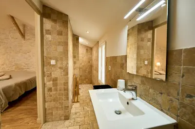a bathroom with a sink and a mirror and a bed at Gîte entier en Campagne in Pernes-les-Fontaines