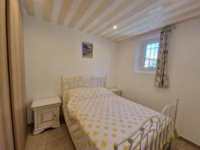 a small bedroom with a bed and a window at la Cigalière in LʼIsle-sur-la-Sorgue