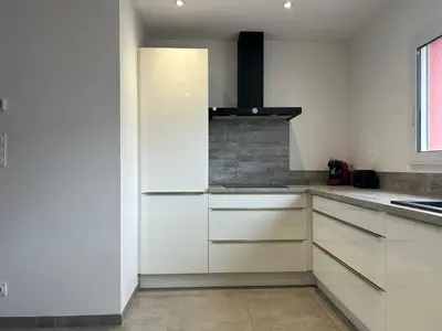 a kitchen with white cabinets and a fireplace at Pitchoun in Velaux