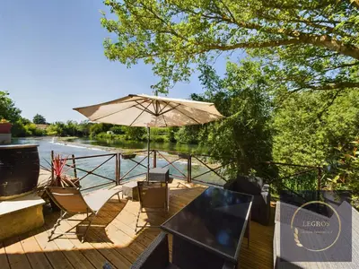 a patio with a table and an umbrella at La terrasse du pêcheur in LʼIsle-sur-la-Sorgue