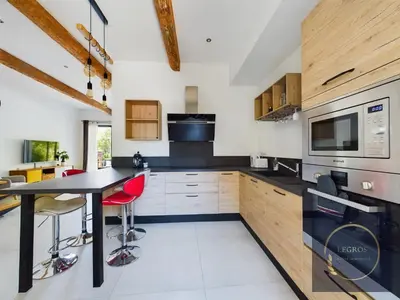 a kitchen with a black table and red chairs at La terrasse du pêcheur in LʼIsle-sur-la-Sorgue