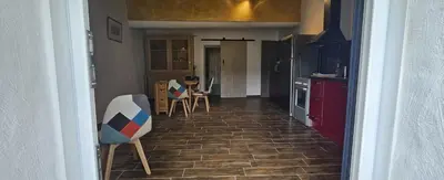 a hallway of a kitchen with chairs and a table at maison O jasmin in Lagnes