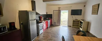 a kitchen with a refrigerator and a table in it at maison O jasmin in Lagnes