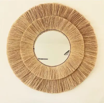 a round mirror on a white background at Appartement à la campagne in LʼIsle-sur-la-Sorgue