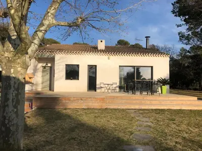 a white house with a deck and a table at Proche Aix-en-Provence maison avec piscine - 10 personnes in Rognes
