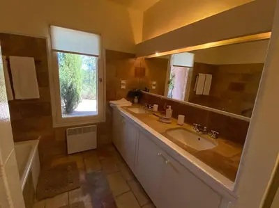 a bathroom with two sinks and a large mirror at Villa Les Gourdeaux in Roussillon