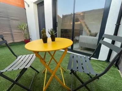 a yellow table and two chairs on a balcony at Studio cosy avec mezzanine in Salon-de-Provence