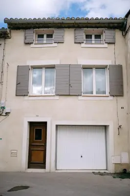 a building with two garage doors and windows at Charming Village House in the Heart of Isle-sur-la-Sorgue in LʼIsle-sur-la-Sorgue