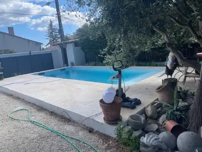 a swimming pool with a hose next to a yard at Maison idéale pour famille proche de toutes commodités in Carpentras