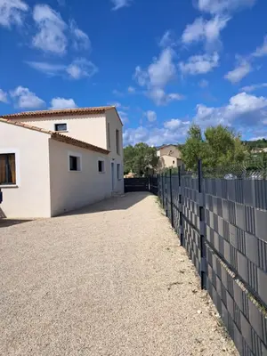 a white house with a fence next to a building at Villa SOFIA in Saint-Saturnin-les-Apt