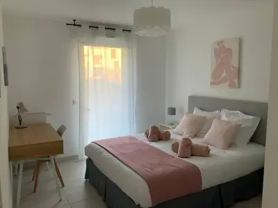 a bedroom with a large bed with two teddy bears on it at Logement cosy climatisé avec parking in Aix-en-Provence