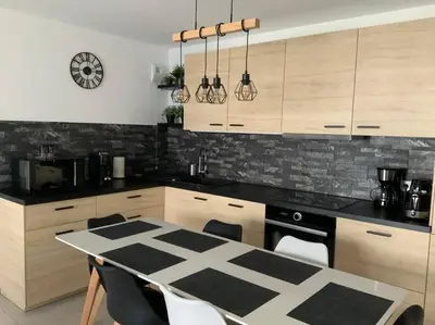 a kitchen with a black and white table and chairs at Logement cosy climatisé avec parking in Aix-en-Provence