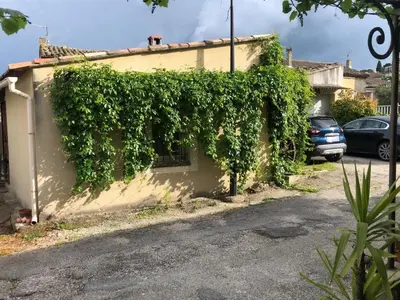 a building covered in green ivy on a street at Parenthèse caumontoise . in Caumont-sur-Durance