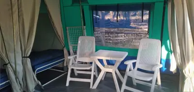 a room with three chairs and a table in a tent at Camping maeva Escapades Le Domaine des Chênes Blancs in Croagnes