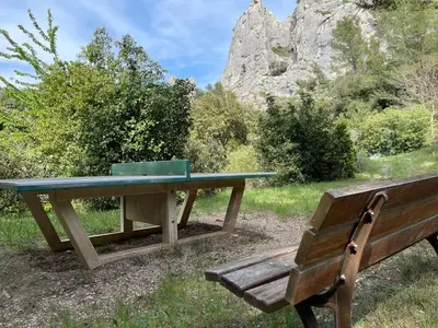 a picnic table and a bench in a park at Camping maeva Respire La Vallée Heureuse in Orgon