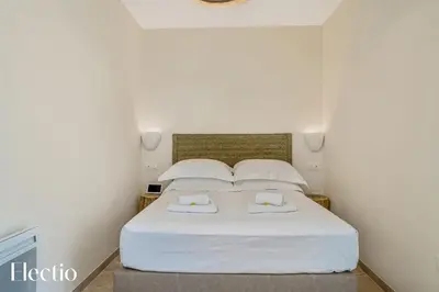 a bedroom with a white bed with two pillows at Villa Oliveda - Piscine & Salon Cinéma in Lourmarin