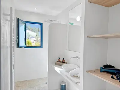 a white bathroom with a sink and a window at Villa Oliveda - Piscine & Salon Cinéma in Lourmarin