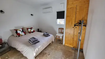 a bedroom with a bed and a wooden door at La Grange des Joumillons in Saint-Saturnin-les-Apt